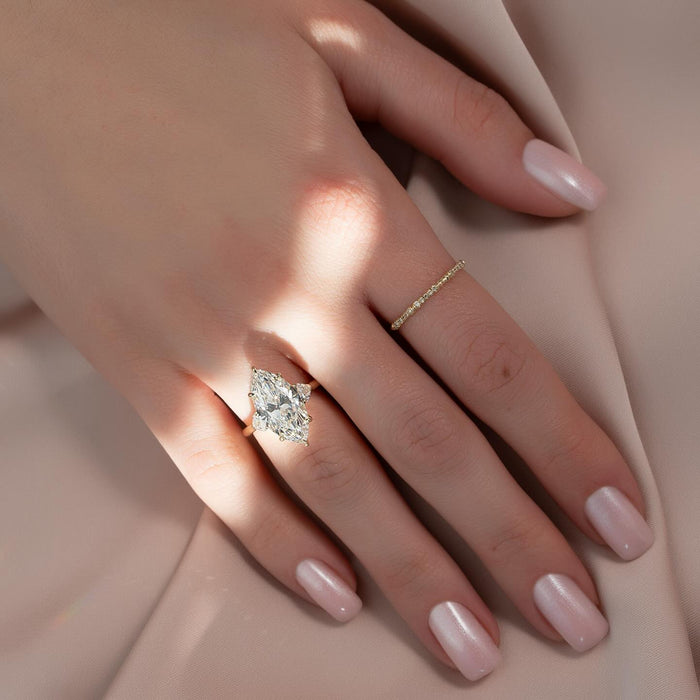 Marquise cut lab grown diamond three stone ring with half moon sides in yellow gold worn on the hand