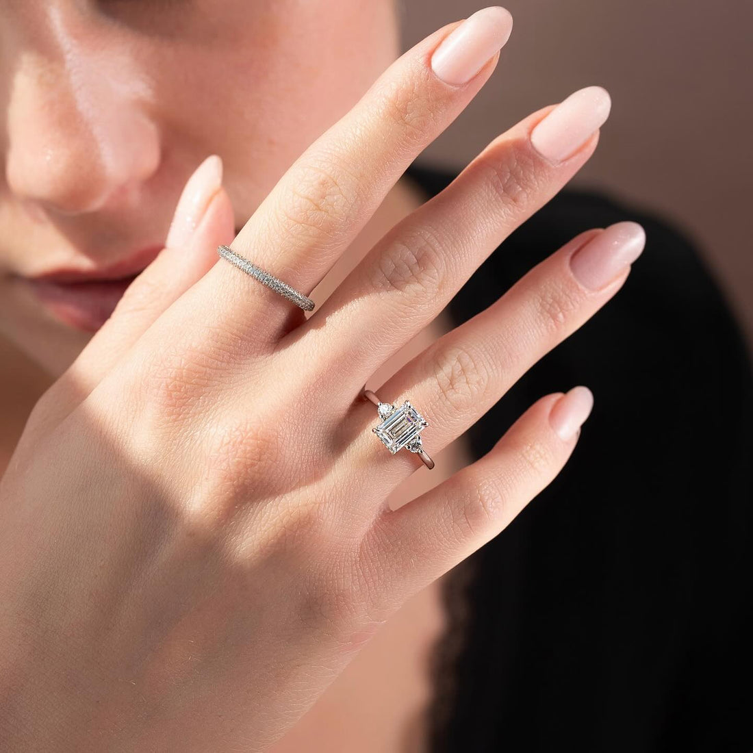 Emerald cut lab grown diamond ring with diagonal accent pair in white gold worn on the hand