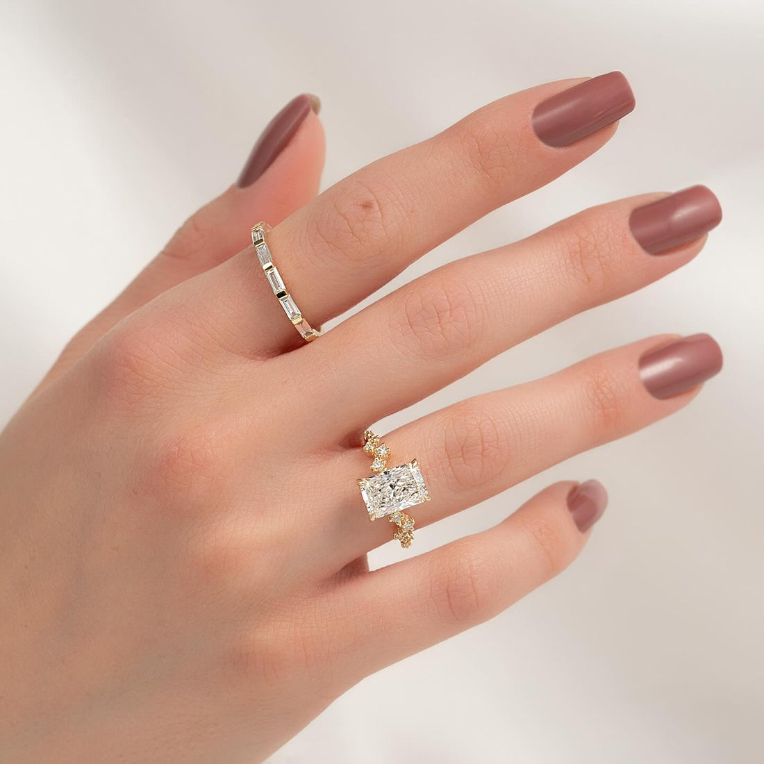 Radiant cut lab grown diamond ring with scattered accent shoulders in yellow gold worn on the hand