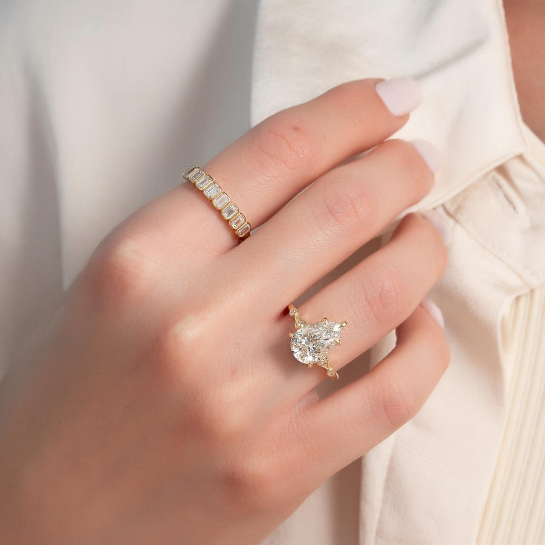 Pear cut lab grown diamond vintage hidden halo ring in yellow gold worn on the hand