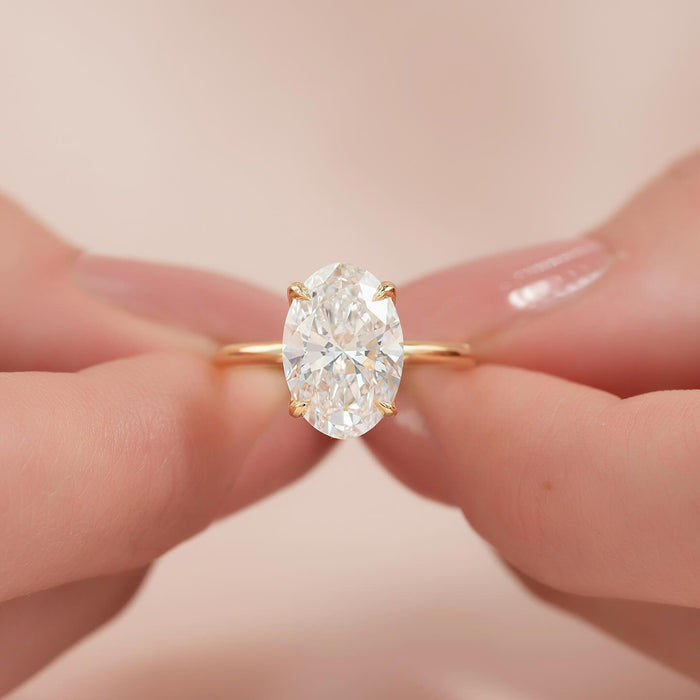 Low open basket holding the oval lab grown diamond close to the finger