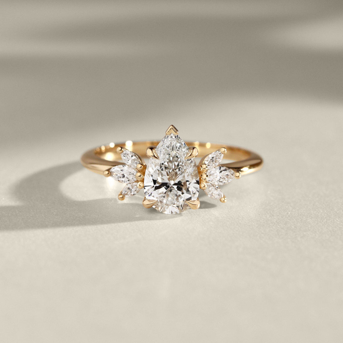 Pear cut lab grown diamond ring with fanned marquise and pear accents in yellow gold
