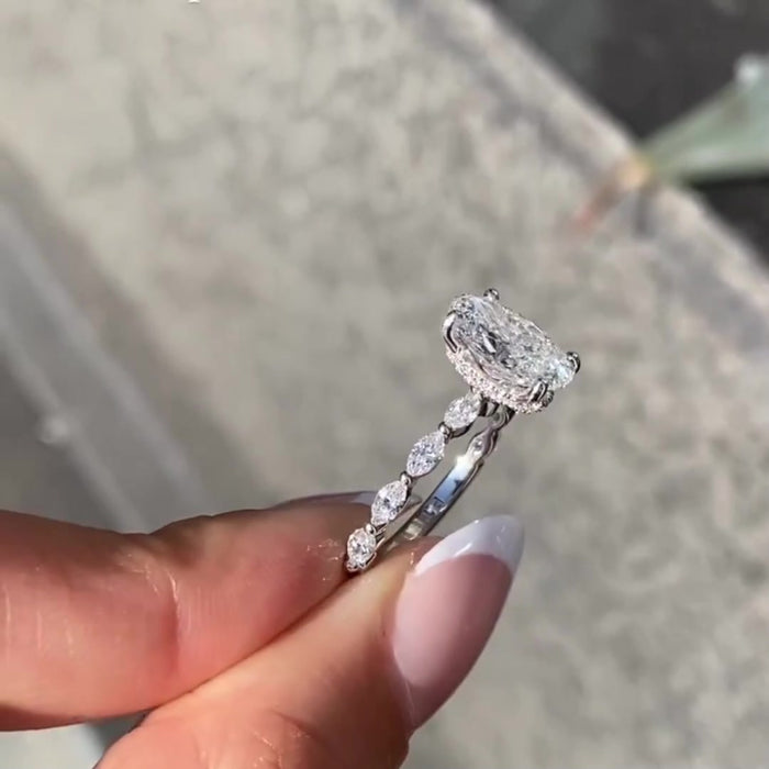 Oval cut moissanite engagement ring with marquise side stones in gold