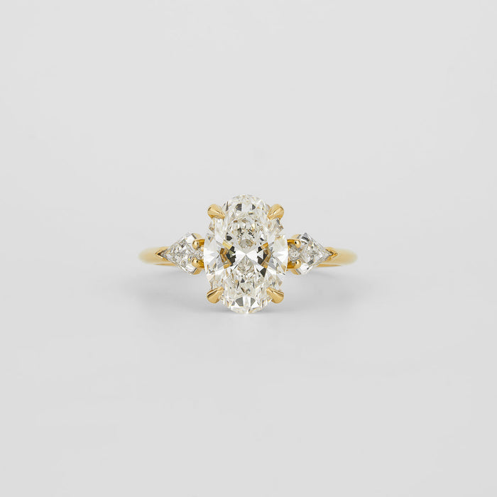 Oval cut lab grown diamond three stone ring with kite cut side stones in yellow gold