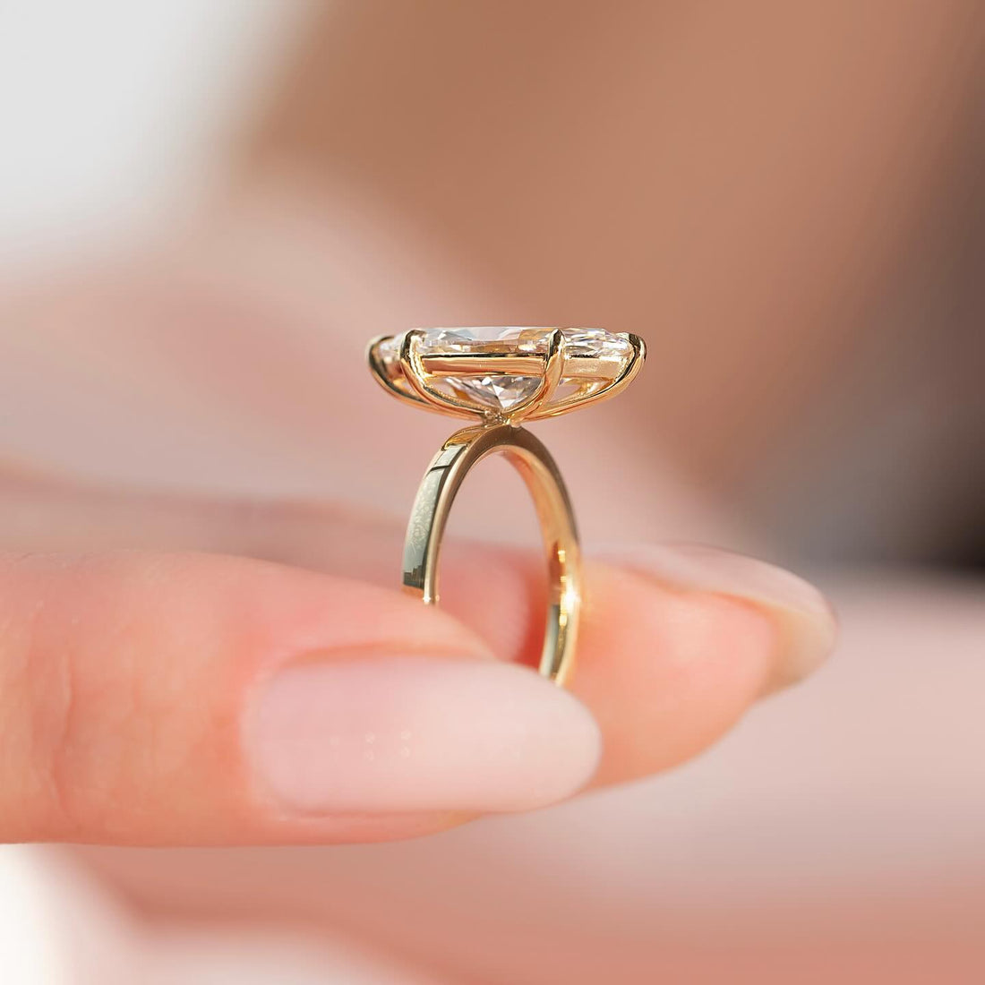 Marquise moissanite solitaire ring with petite band side profile in yellow gold