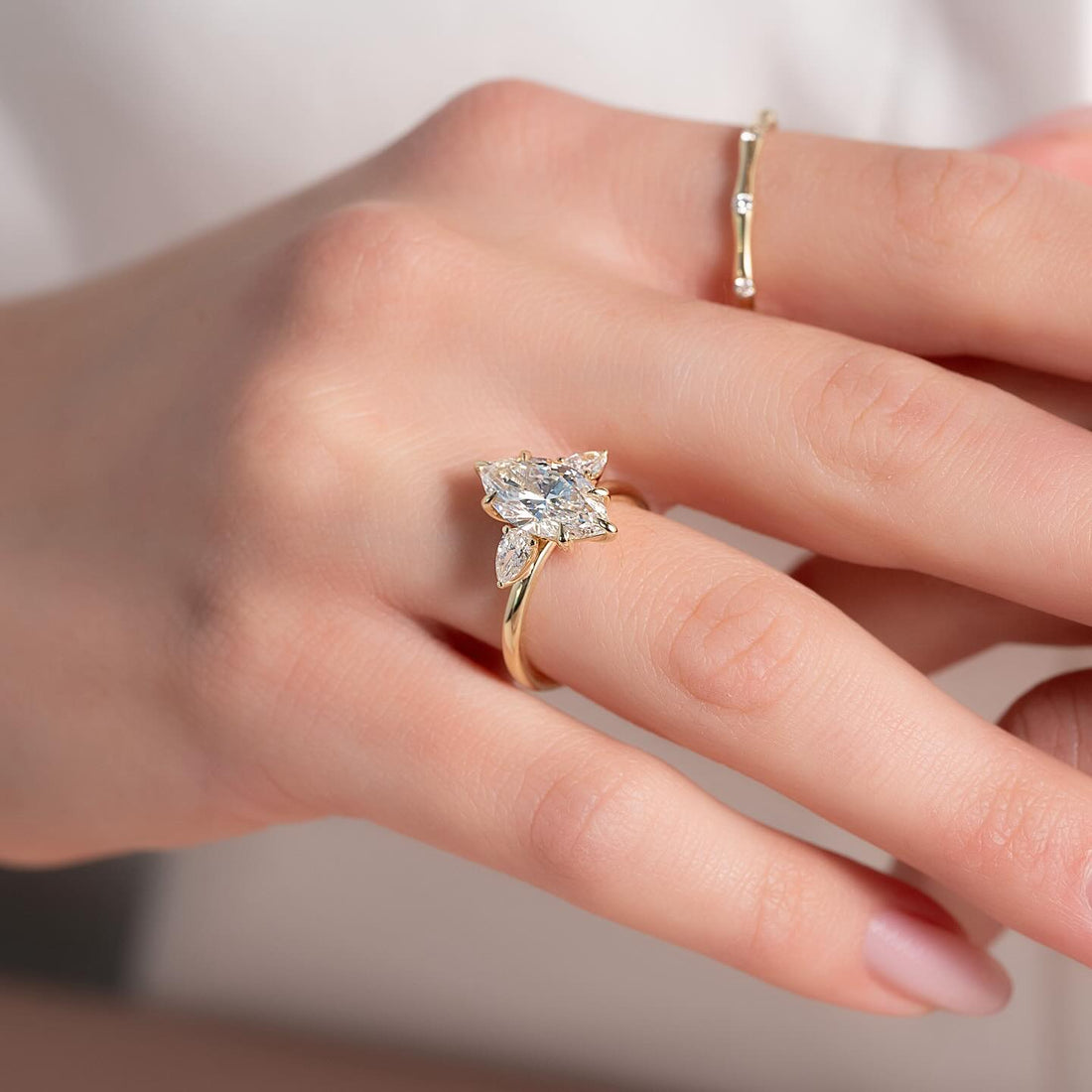 Marquise moissanite pear cluster ring worn on hand in yellow gold