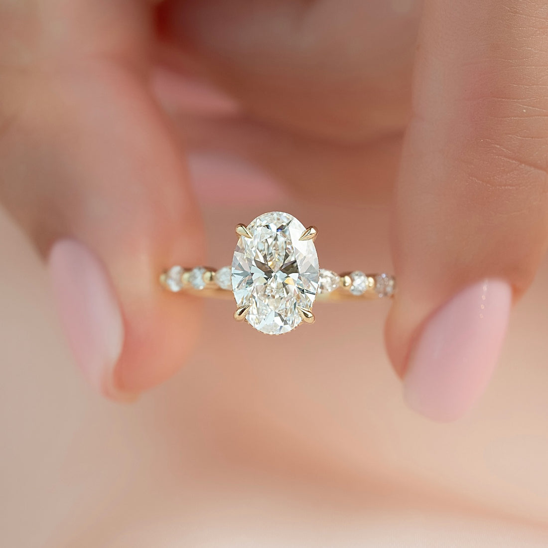 Oval moissanite hidden halo spaced marquise band ring worn on hand in yellow gold