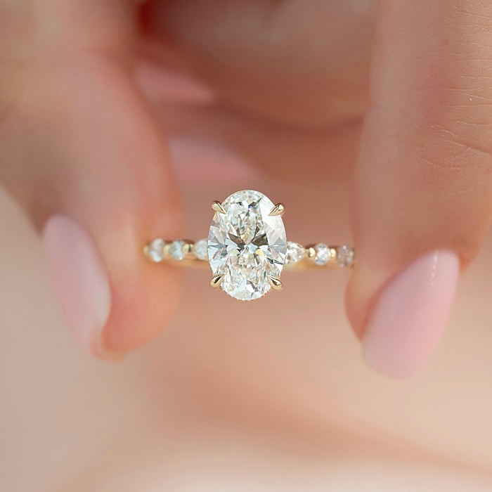 Oval moissanite hidden halo spaced marquise band ring worn on hand in yellow gold
