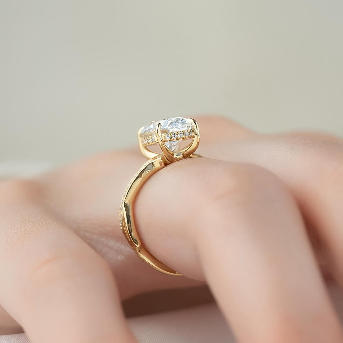 Oval moissanite hidden halo pave twig band ring side profile in yellow gold