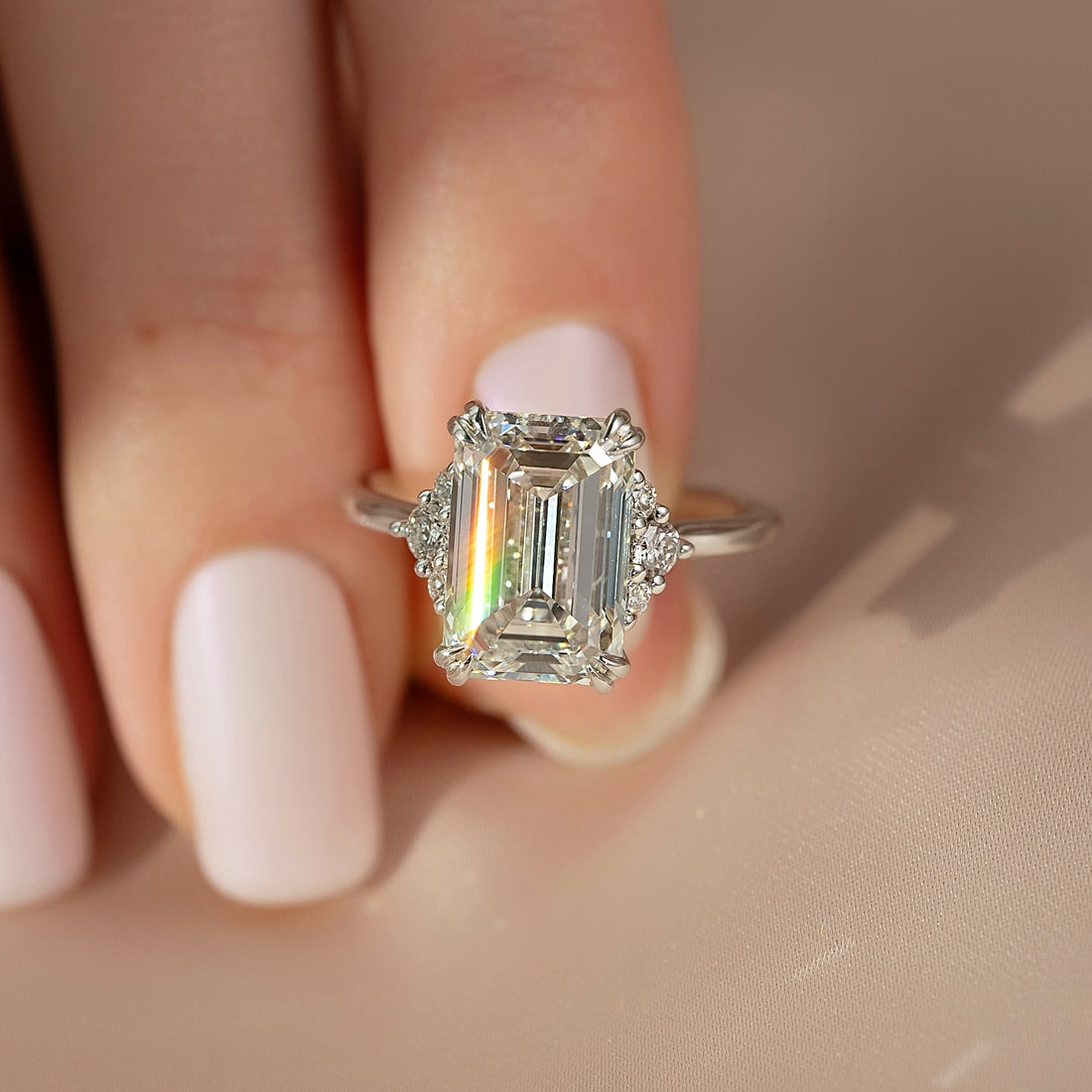 Emerald cut moissanite ring with trio cluster side accents in white gold