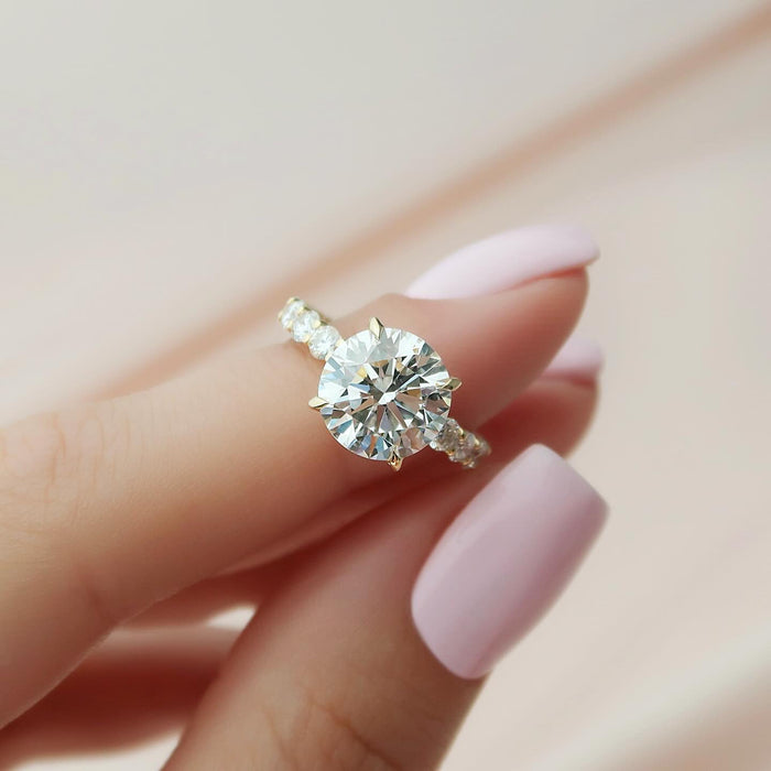 Round moissanite hidden halo ring with accent band in yellow gold