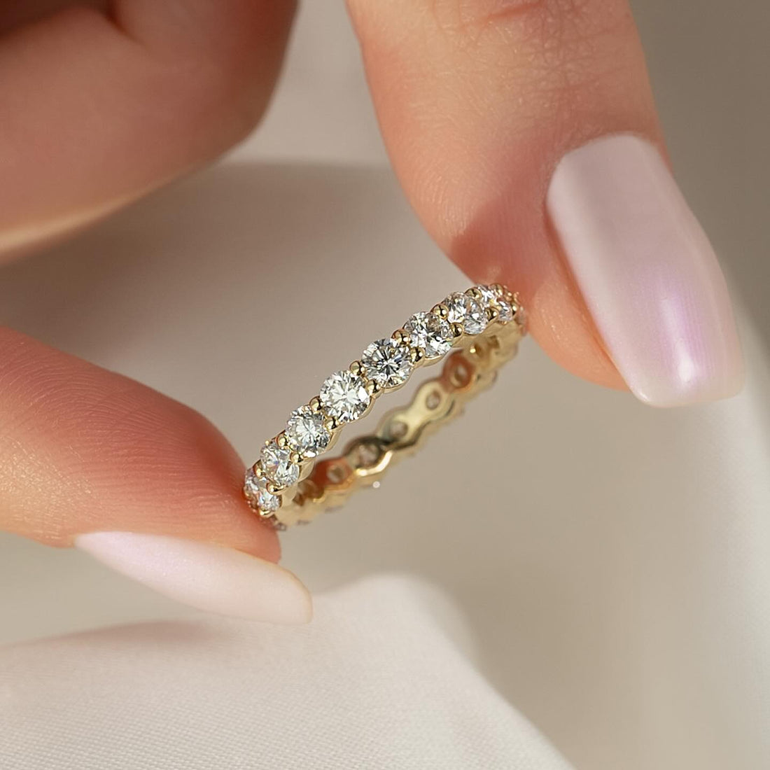 Round moissanite shared prong full eternity band in yellow gold