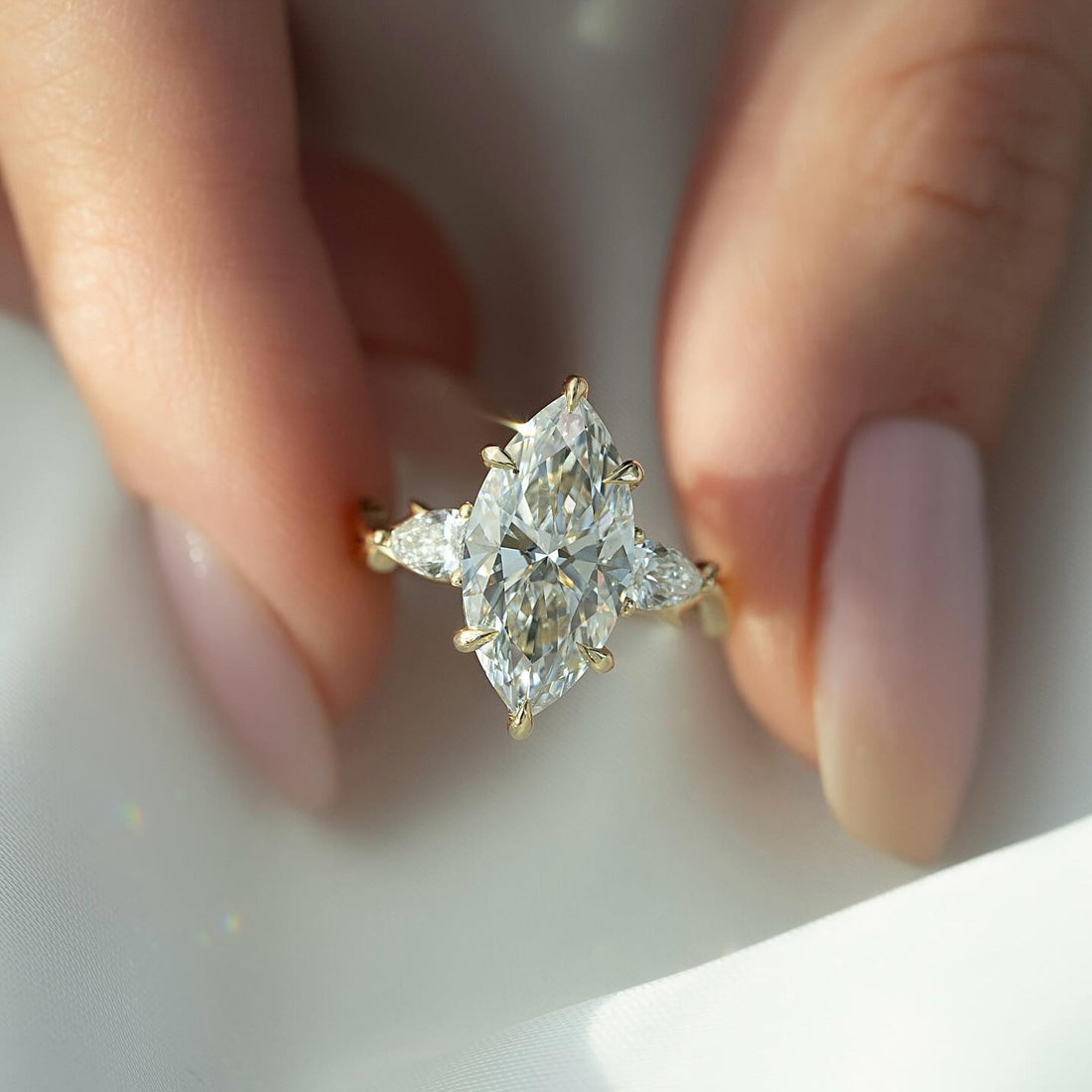 Marquise moissanite ring with pear side accents on twig band in yellow gold