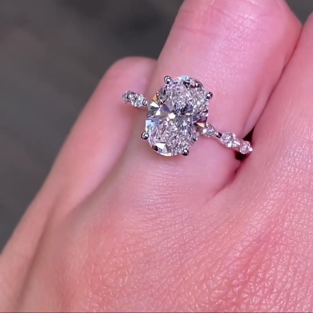 Oval cut moissanite engagement ring with marquise side stones in gold