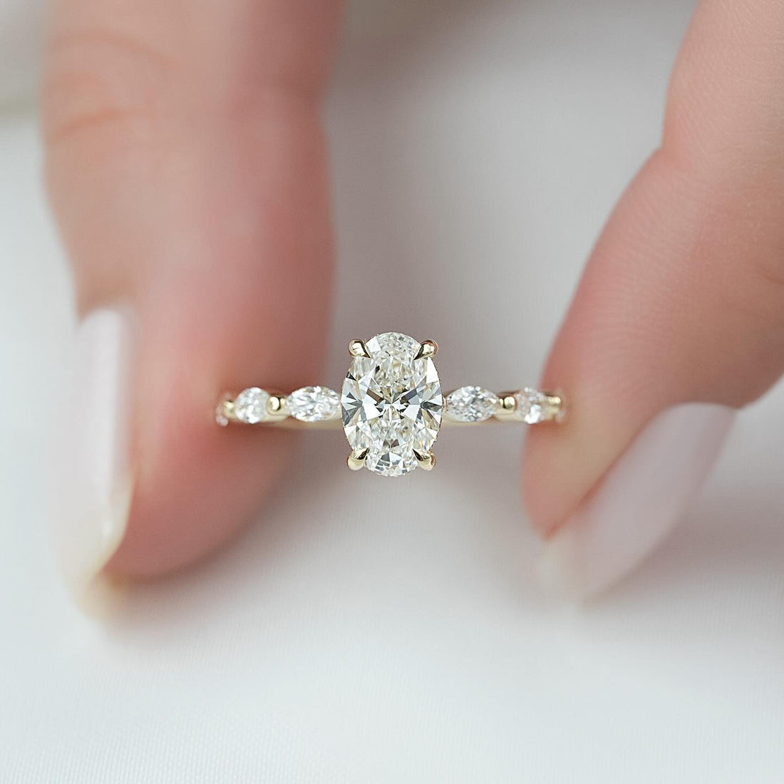 Oval moissanite ring with hidden halo and marquise accent band in 14K yellow gold