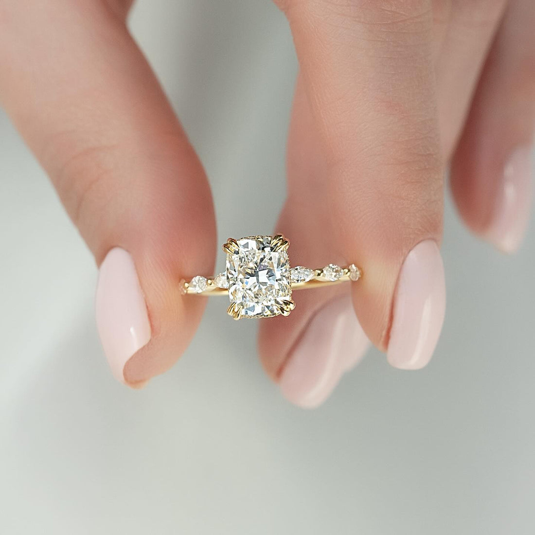 Elongated cushion moissanite ring with hidden halo and marquise accent band in 14K yellow gold