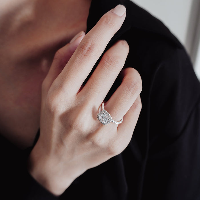 Cushion halo engagement ring seen on the finger