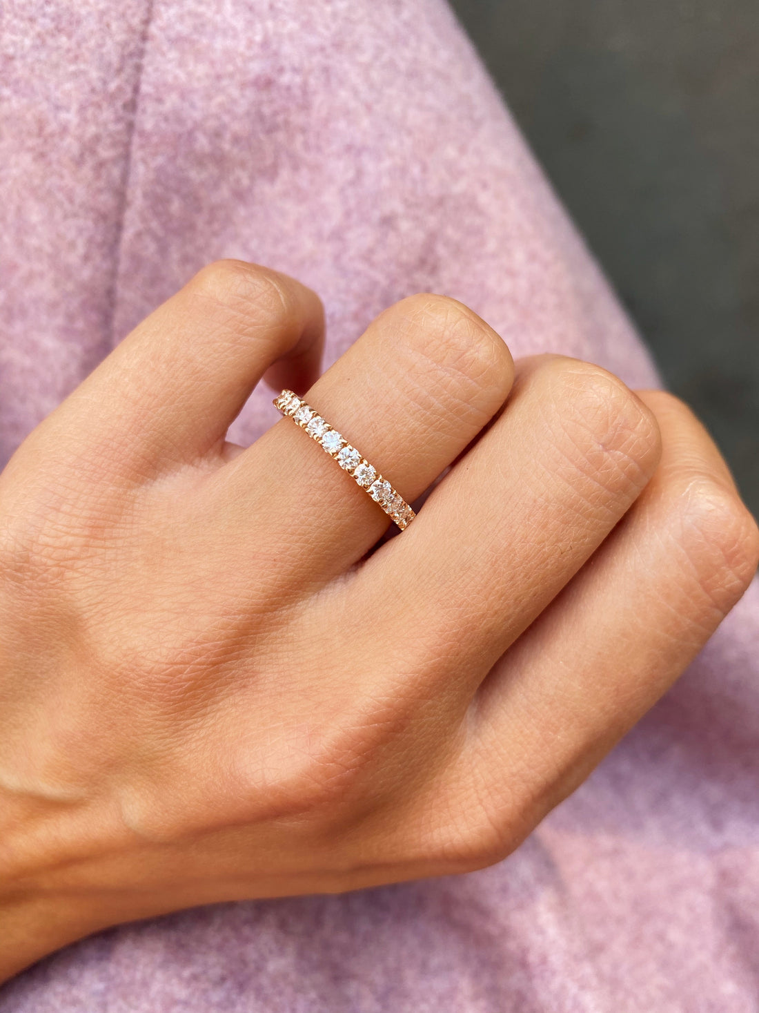 Round full eternity lab grown diamond wedding band in rose gold worn on the ring finger