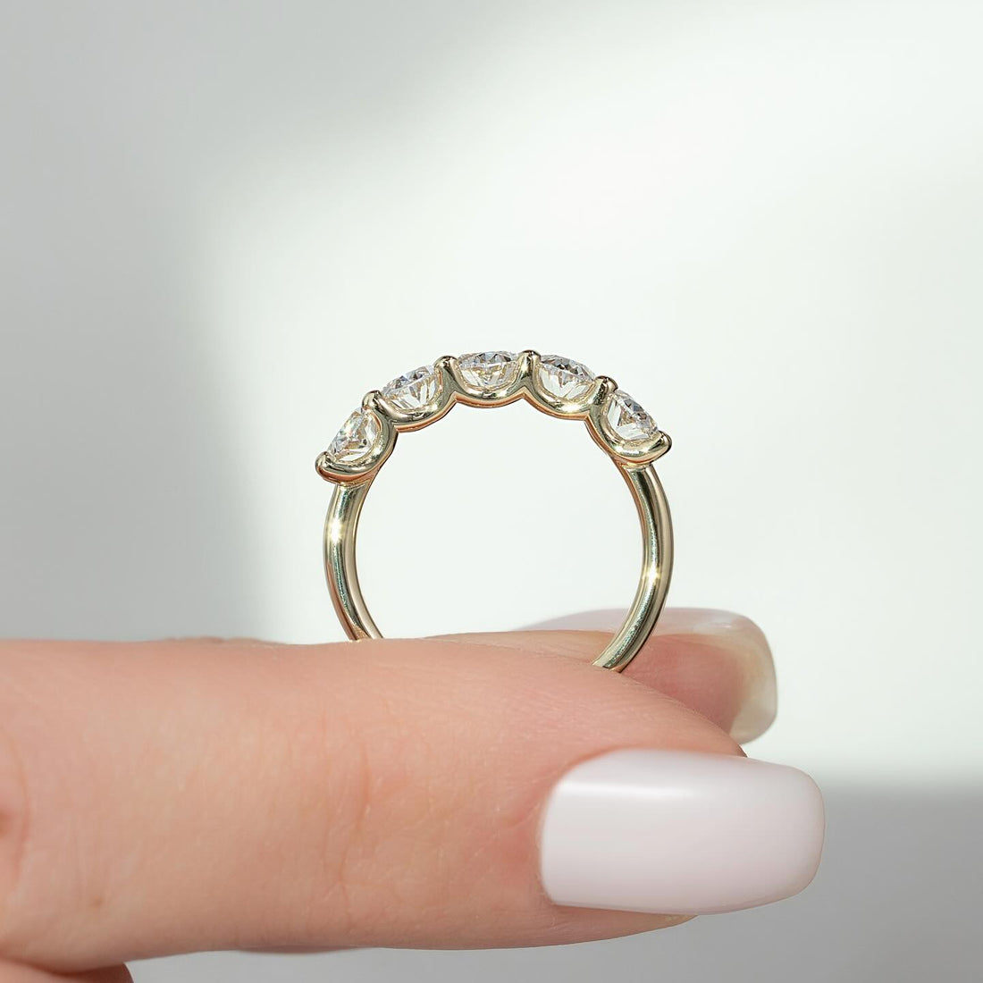 Oval cut moissanite half eternity wedding band in 14K yellow gold side profile