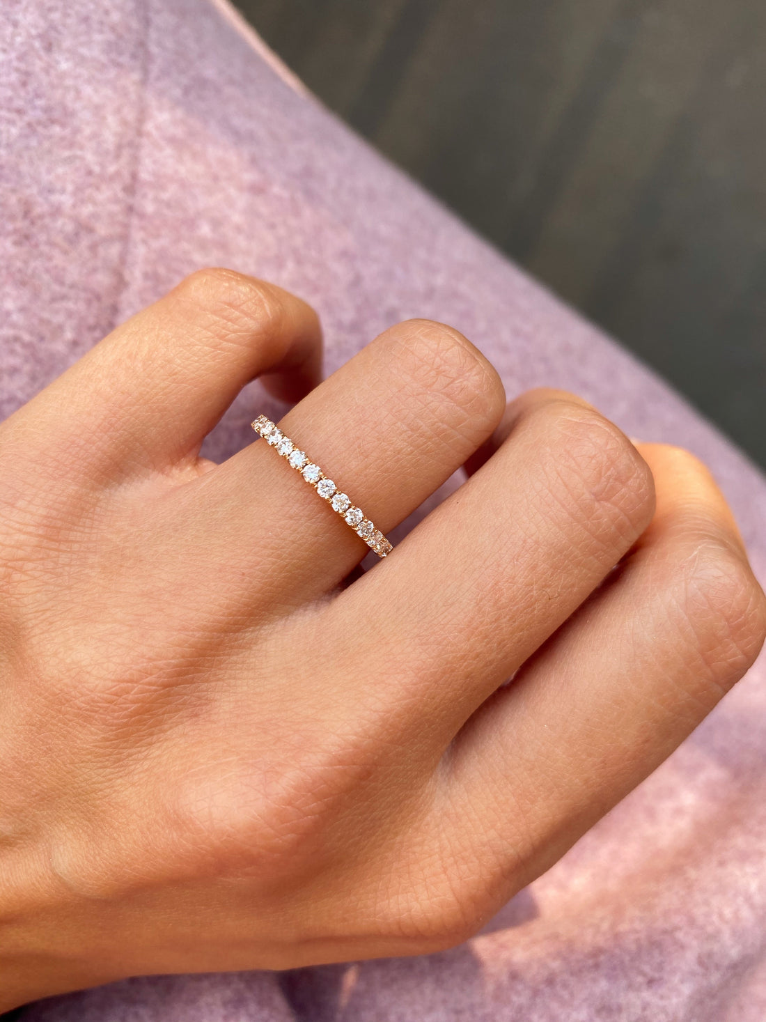 Round full eternity lab grown diamond wedding band in rose gold worn on the ring finger