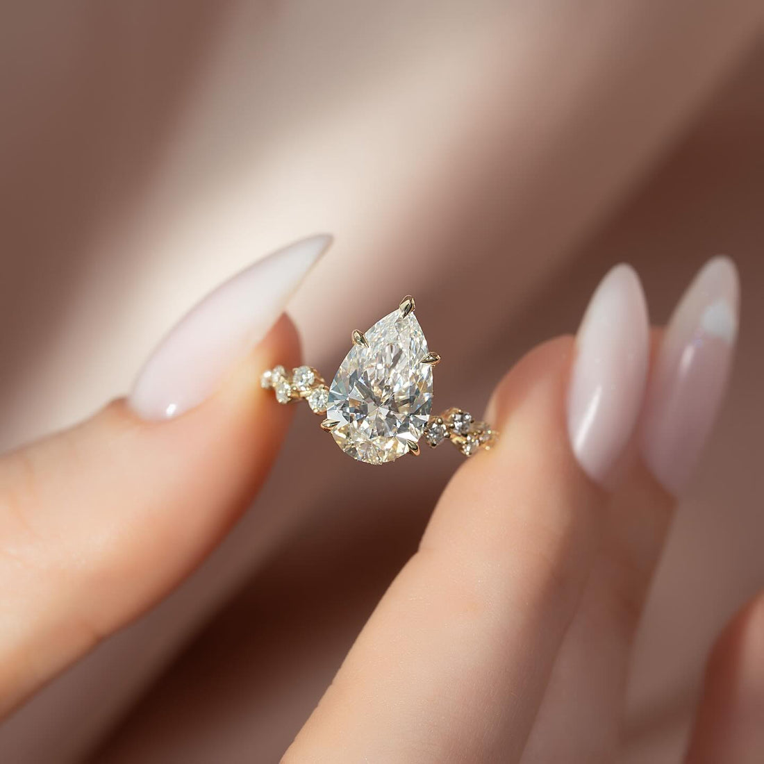 Pear cut moissanite hidden halo cluster accent ring in 14K yellow gold