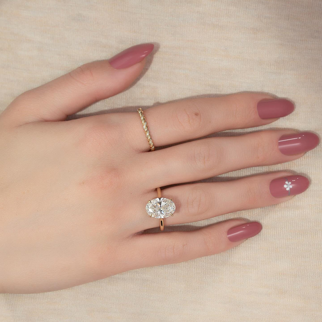 Oval cut moissanite hidden halo knife edge solitaire ring in 14K yellow gold on hand
