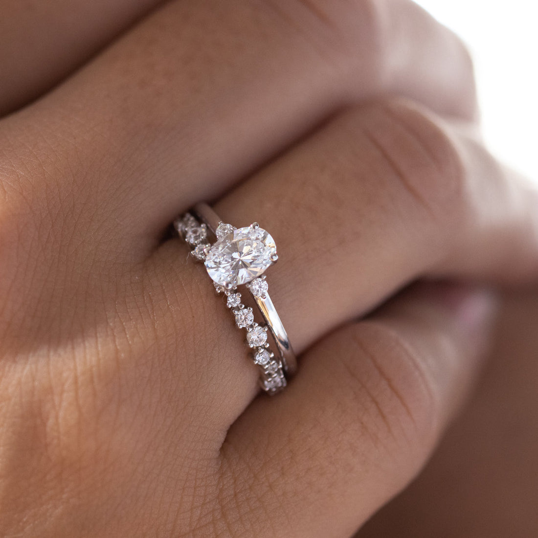 Oval engagement ring worn with a slim white gold graduated moissanite eternity band, the engagement ring is not included