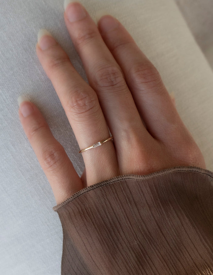 Slim baguette moissanite stacking ring worn on the ring finger