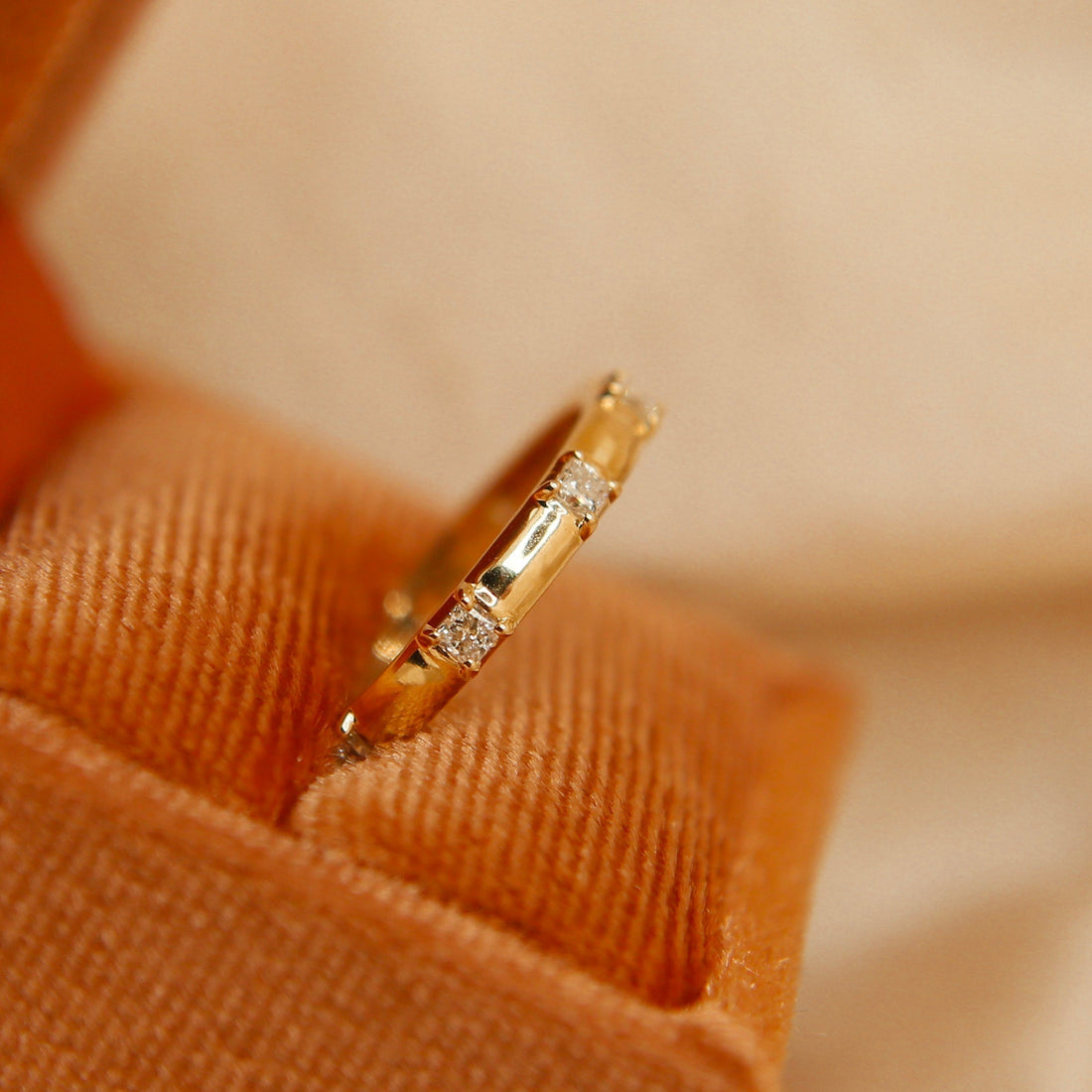 Close view of a princess lab grown diamond multi stone wedding band in yellow gold