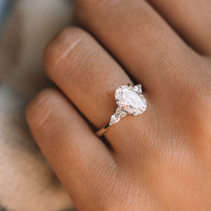 Oval Cut Moissanite Three Stone Pear Accent Engagement Ring - on hand view 1