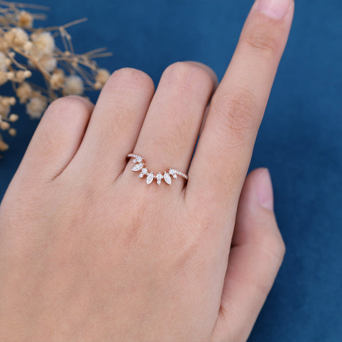 Marquise and round moissanite curved cluster wedding band in rose gold worn on a finger