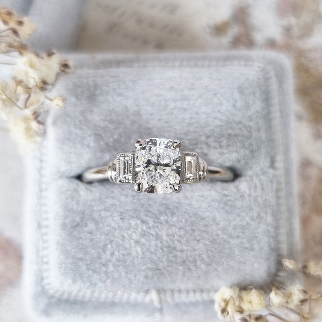 Cushion cut lab grown diamond three stone ring with bezel set baguette shoulders