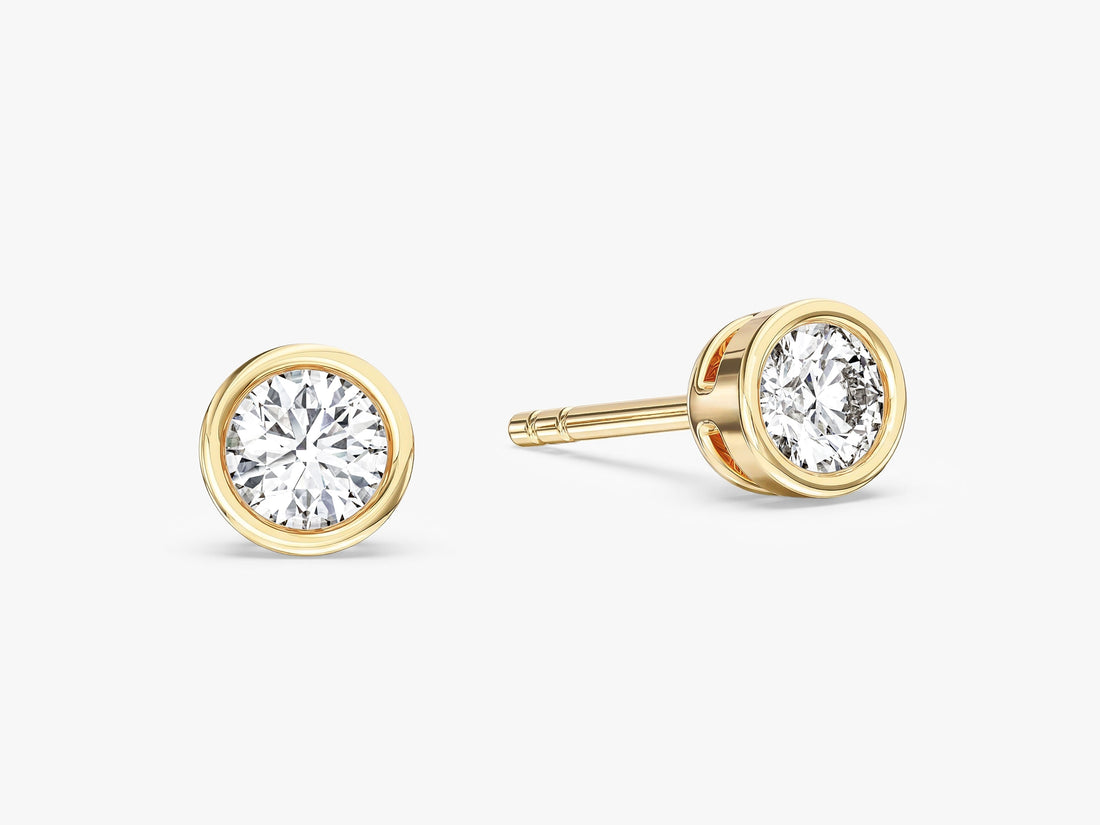 Pair of minimalist round bezel moissanite stud earrings in yellow gold