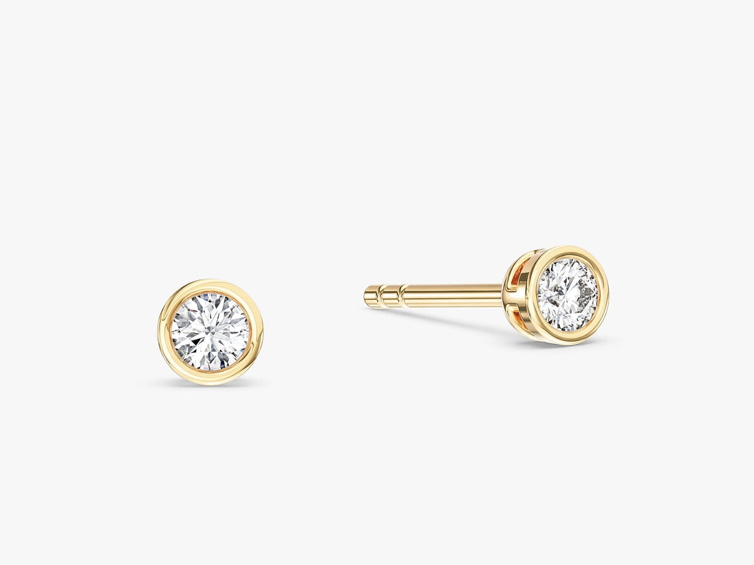Pair of bezel set round moissanite stud earrings for women in yellow gold
