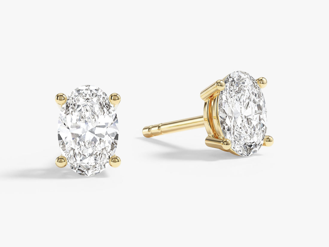 Pair of oval cut moissanite solitaire stud earrings in yellow gold