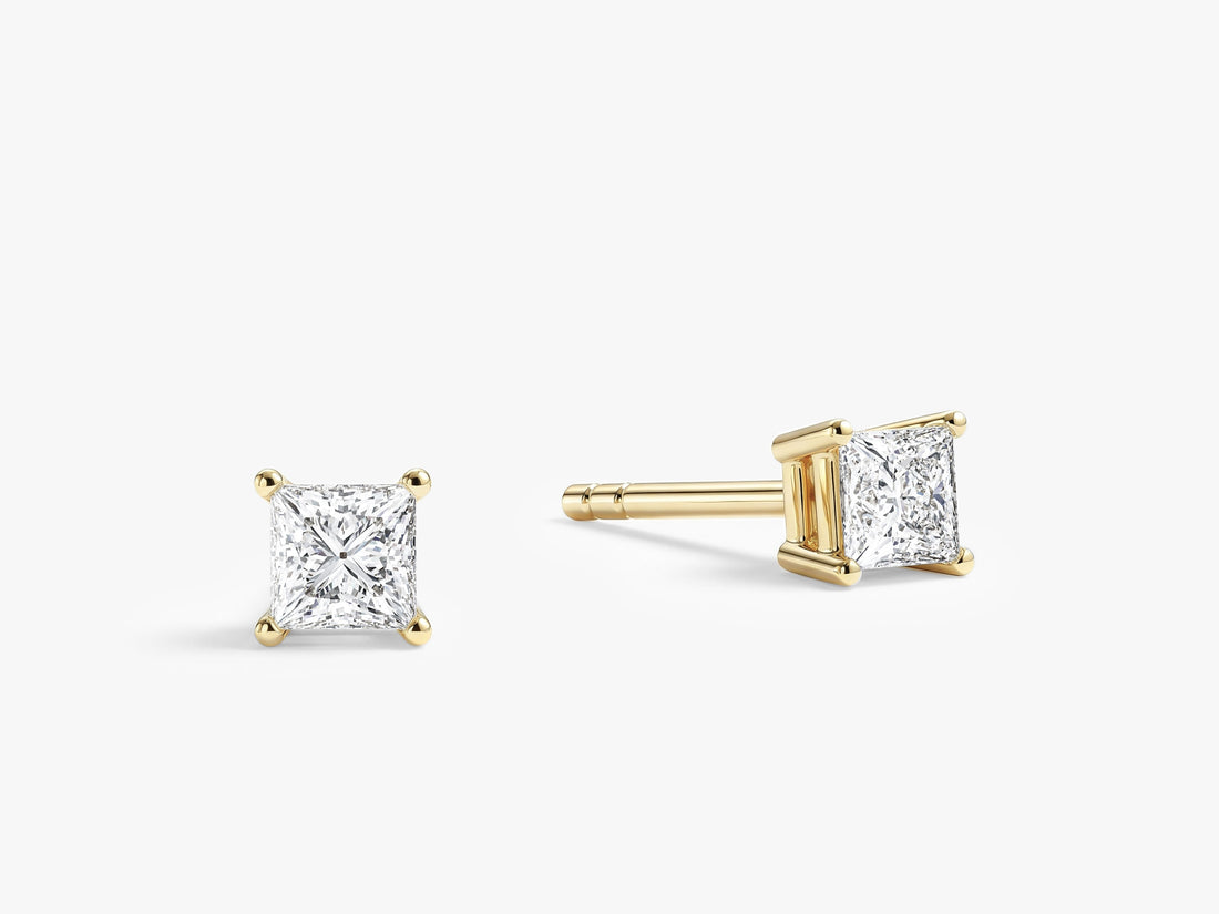 Pair of four prong princess cut moissanite stud earrings in yellow gold