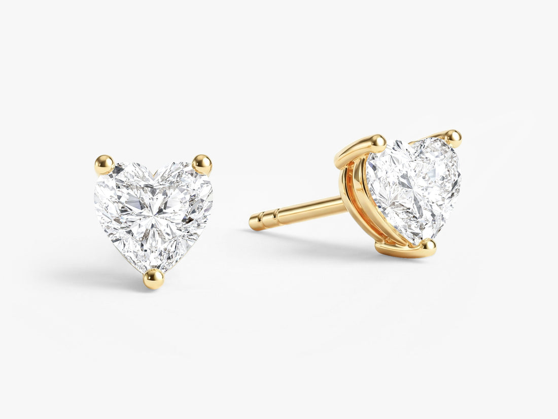 Pair of heart cut moissanite solitaire stud earrings in yellow gold