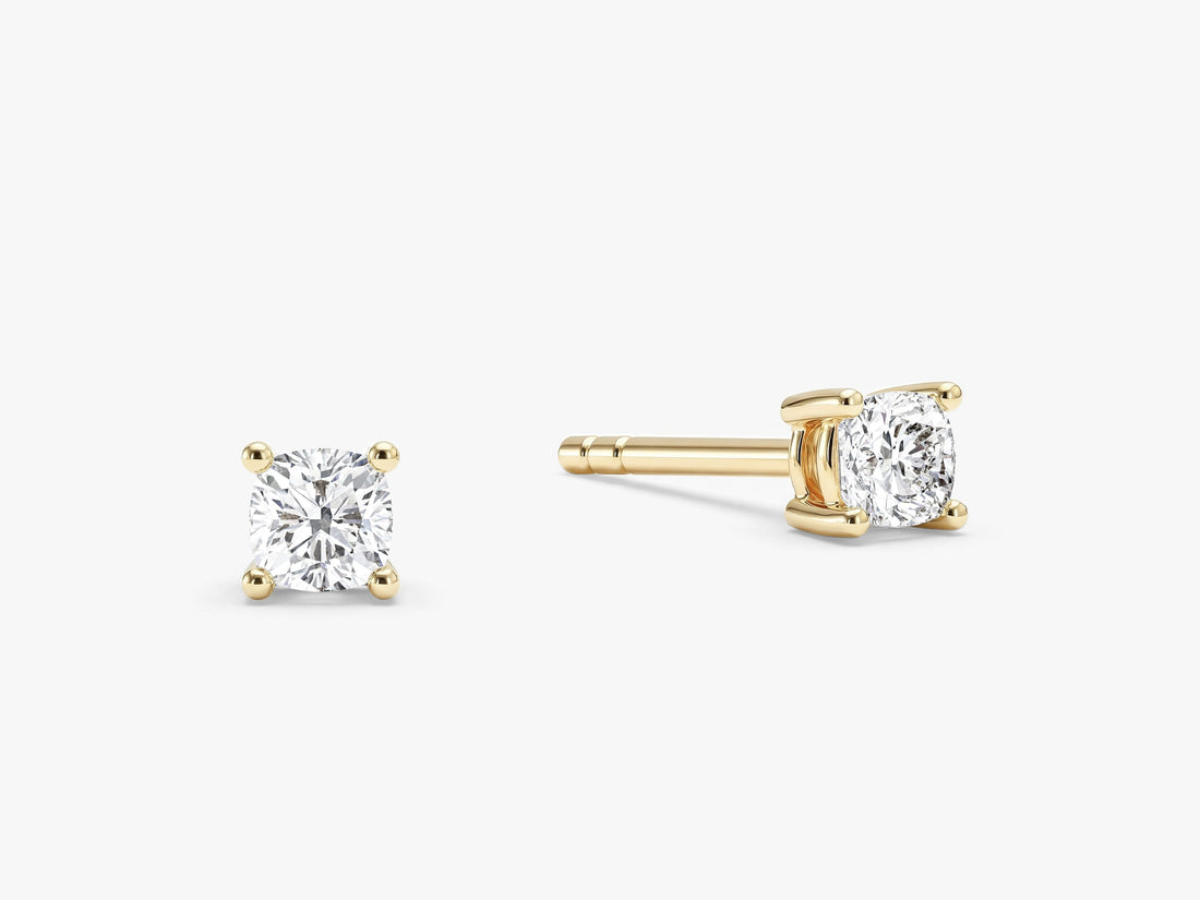 Pair of four prong cushion cut moissanite stud earrings in yellow gold