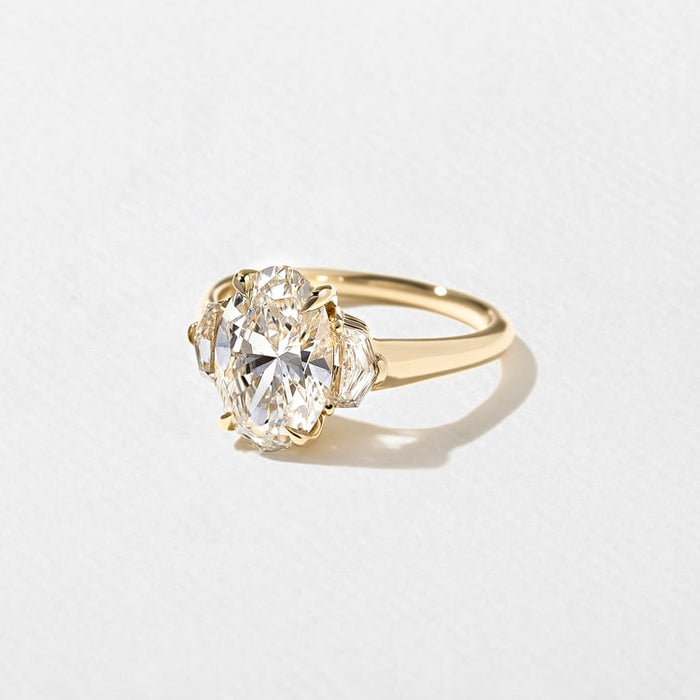 Angled view of the oval and half moon lab grown diamond three stone ring
