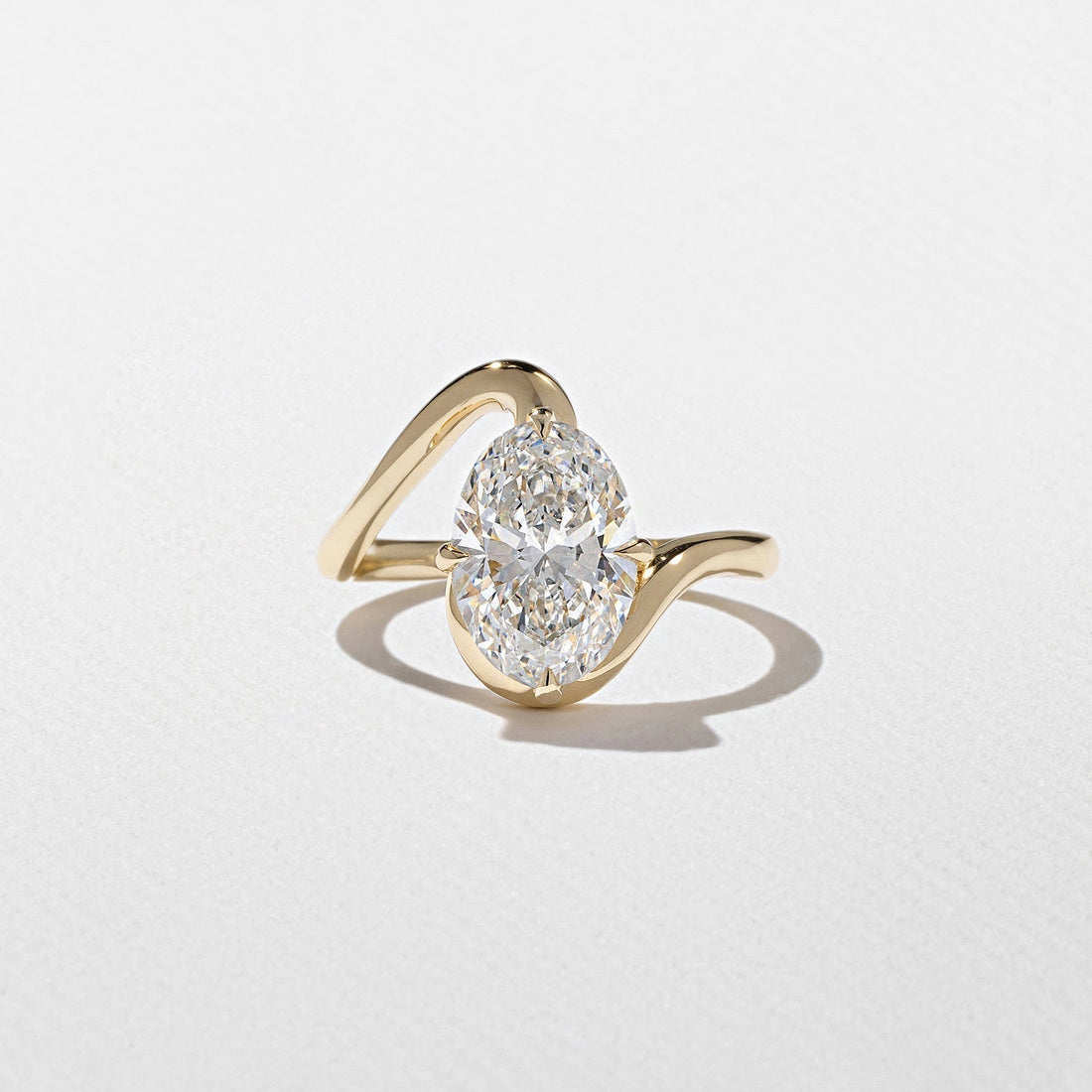 Oval cut lab grown diamond sculptural swirl engagement ring in yellow gold