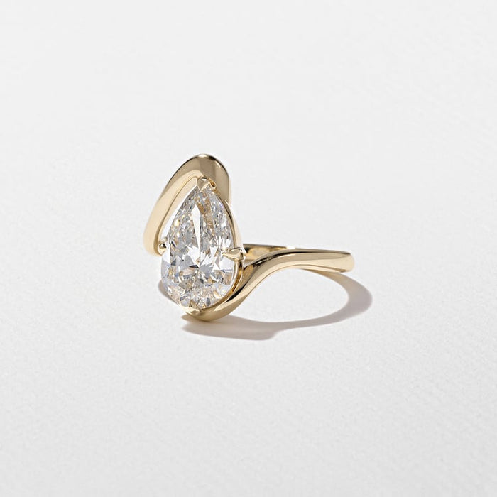 Pear cut lab grown diamond sculptural swirl engagement ring in yellow gold