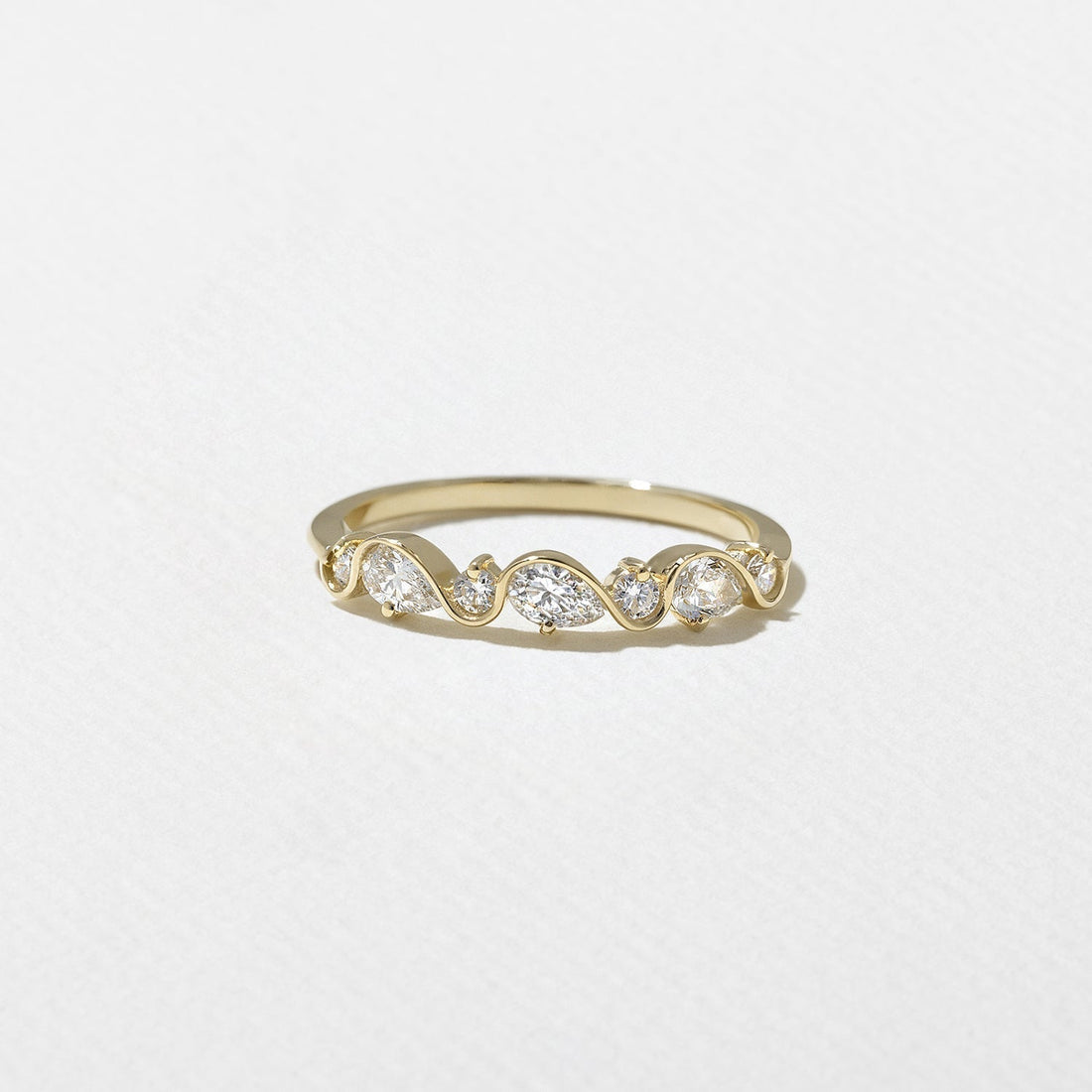 Round and pear lab grown diamond wavy half eternity wedding band in yellow gold