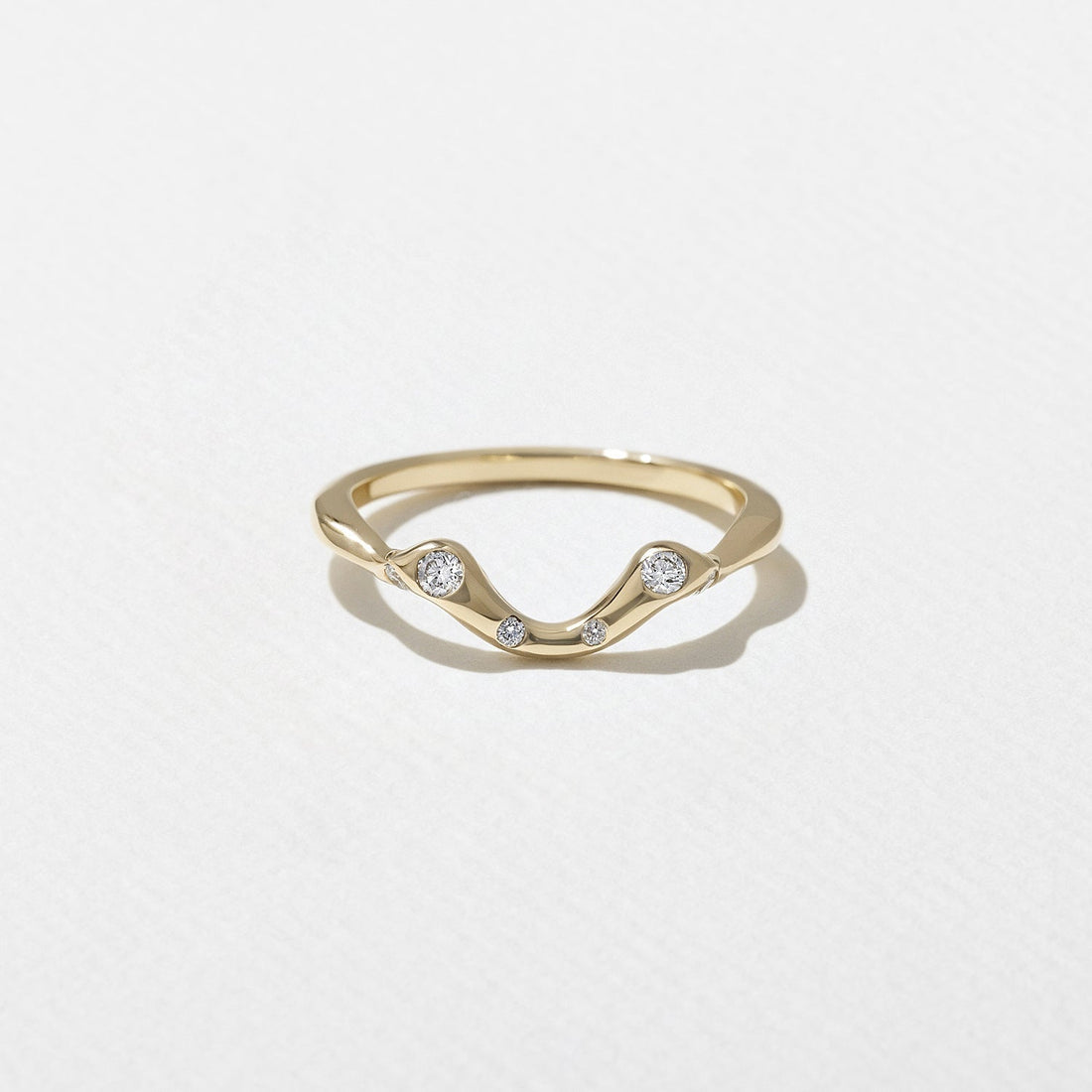 Round lab grown diamond scattered curved wedding band in yellow gold