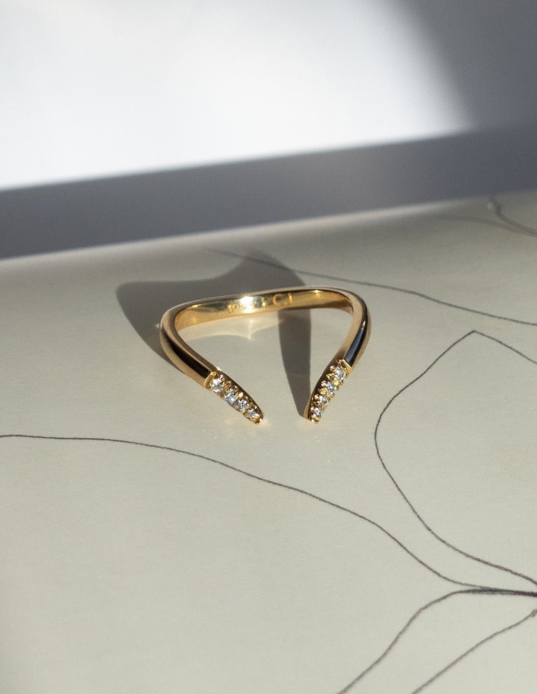 Open V wedding band in gold with round moissanite on both tapered tips
