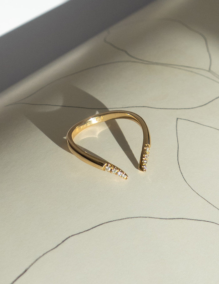 Open V gold wedding band with moissanite tips, angled view