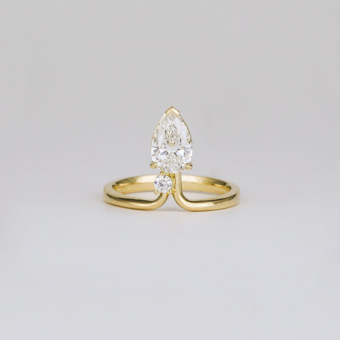 Pear cut lab grown diamond ring on a chevron band in yellow gold