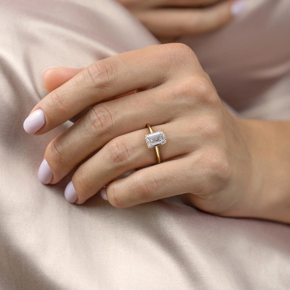Emerald cut moissanite hidden halo solitaire engagement ring with four claws and a thin polished band