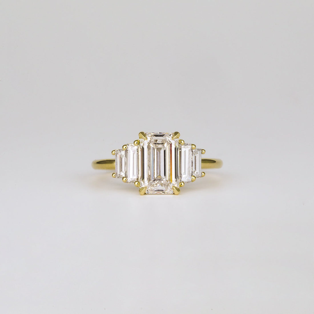 Emerald cut lab grown diamond five stone step cut ring in yellow gold