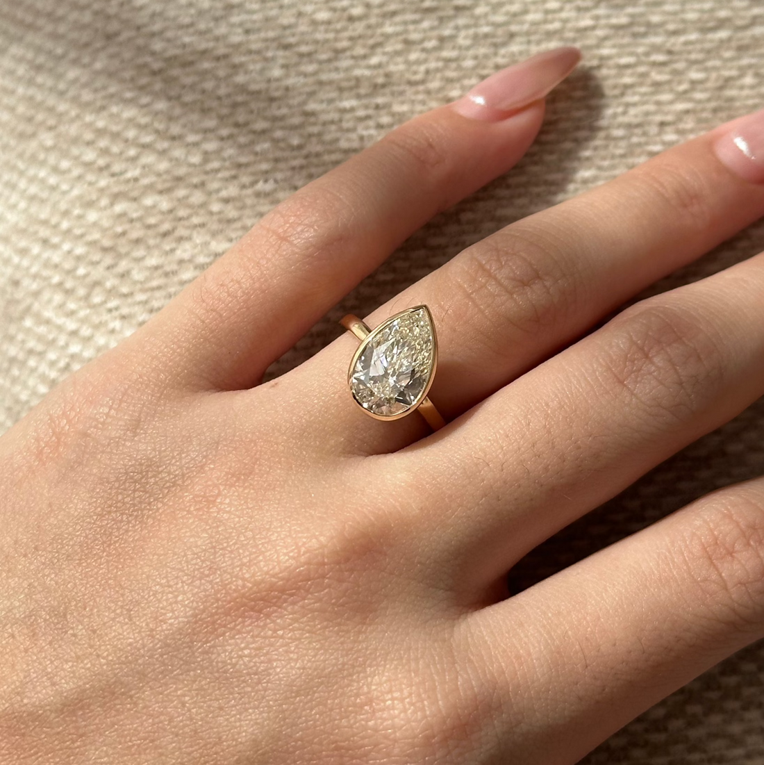 Pear cut lab grown diamond chunky bezel solitaire ring on a rounded yellow gold band