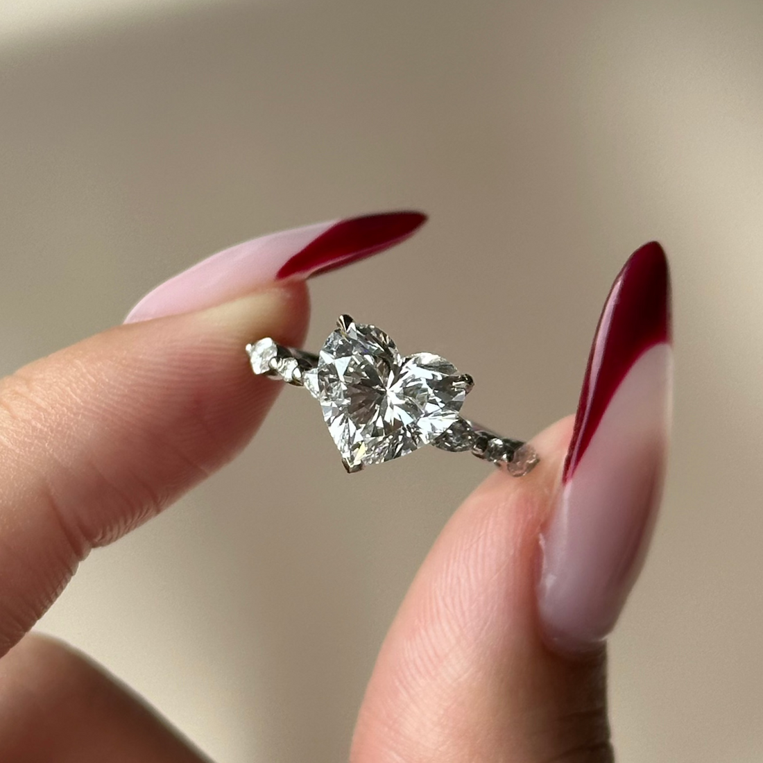 Heart cut lab grown diamond ring held in the fingers
